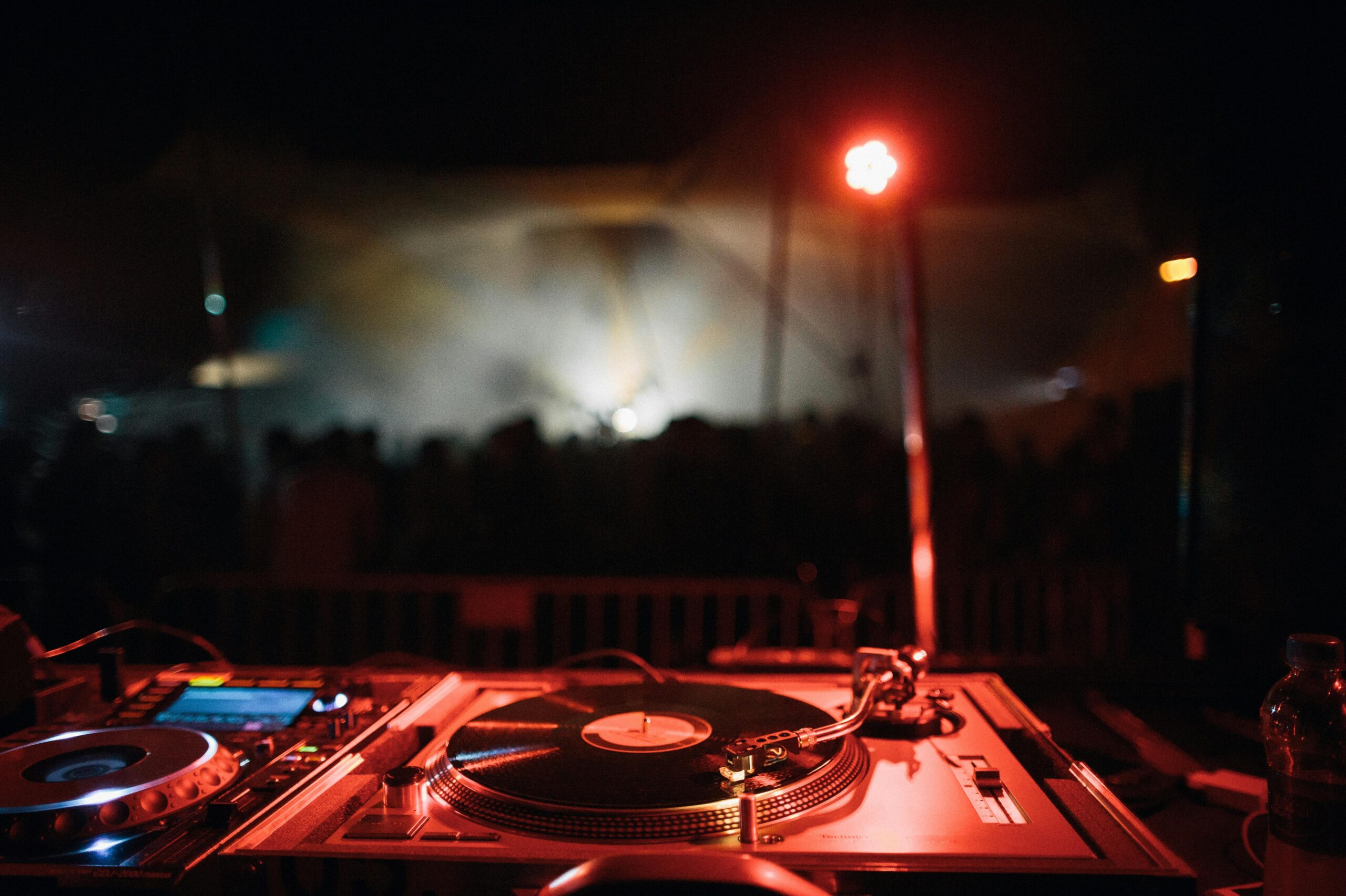 Dynamic view of DJ turntables in a vibrant nightclub at night.